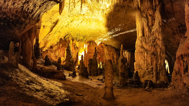 Tourists enjoying a guided tour walking on the footpath inside the famous postojna cave, a natural wonder in slovenia