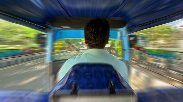 Auto rickshaw driver navigating through busy streets with motion blur effect capturing speed and movement