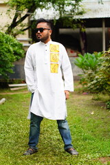 A boy wearing dark glasses and a Punjabi is greeting the puja