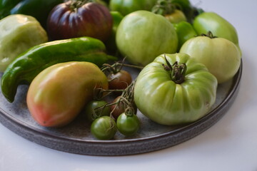 Fresh Green and Heirloom Tomatoes with Peppers on a Plate