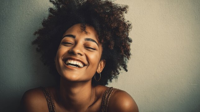 laughing african american woman with an afro hairstyle and good sense of humor smiling as she tilts her head back to look into the air no logos no brands ar 169