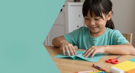 Naklejka premium Creative Asian girl making origami at home. Child learning a new hobby with paper art and craft supplies. Childhood education concept with copy space