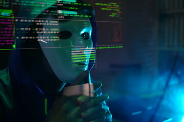 male hacker wearing a white mask sits in front of a screen, hands typing amid glowing cyber attack alerts and red binary code, symbolizing hacking, data breach, and malware in the night