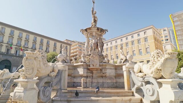 NAples, Italy. Triton Fountain in Piazza Municipio with flowing water. In the background the Town Hall. Sunny spring day. Real time 4K video. 
