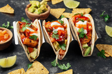 Mexican Fish Tacos with fresh vegetables, sour cream and chilli sauce