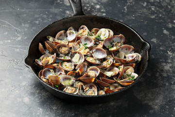 Steamed Clams with garlic, parsley and white wine in a cast iron pan