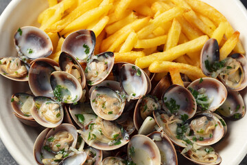 Steamed Clams with herbs and French fries in a white plate