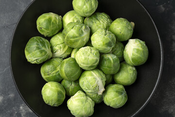 Fresh Brussels Sprouts in a black plate. Healthy food.