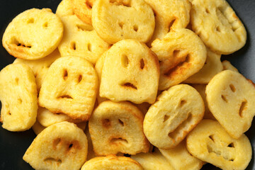 Fried Halloween potato shapes on black plate.