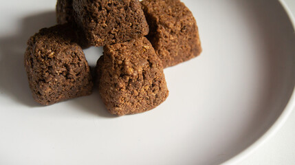 Close-up of delicious chocolate truffles with golden wrappers, with a white background.