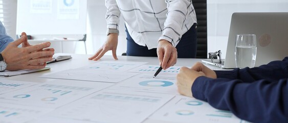 Business team analyzing financial charts during strategy meeting, professionals discussing data and performance metrics at workplace for decision making success