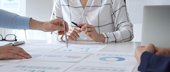 Business meeting with colleagues discussing financial charts, strategy planning, and analyzing data reports during a professional teamwork collaboration session