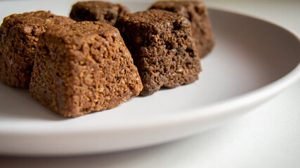 Close-up of delicious chocolate truffles with golden wrappers, with a white background.