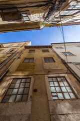 Obraz premium A low-angle view captures the weathered facades of tall, narrow buildings