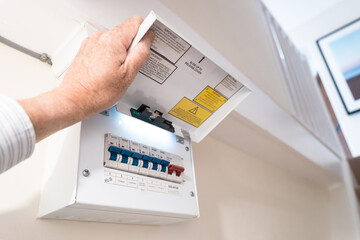 Close-up of a modern, domestic fuse and circuit breaker cabinet in a typical household. Various...
