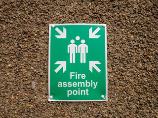 Obraz premium Green fire assembly point sign on wall