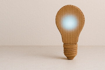 Cardboard light bulb glowing paper idea concept. Space for text.