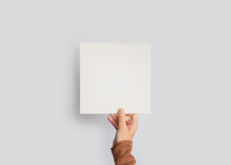 Hand Holding Blank Square Card Mockup on Grey Background