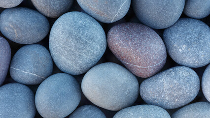 Pebbles stones on seashore as  texture background for design web banner template page. SPA concept background.