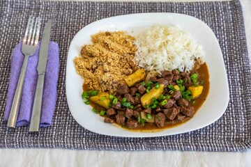 The most traditional Brazilian dish known as picadinho de carne, prepared with cubes of tender, lean beef in a stew with a sauce with typical seasoning and spices, accompanied by white rice and banana