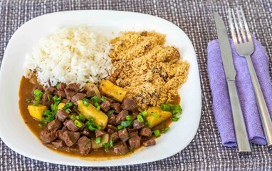 The most traditional Brazilian dish known as picadinho de carne, prepared with cubes of tender, lean beef in a stew with a sauce with typical seasoning and spices, accompanied by white rice and banana