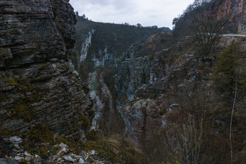Rocky landscape of the Voidomatis Potamos valley in the Zagoria region at Pindus Mountains on a dark winter day with atmospheric mood, Epirus, Greece