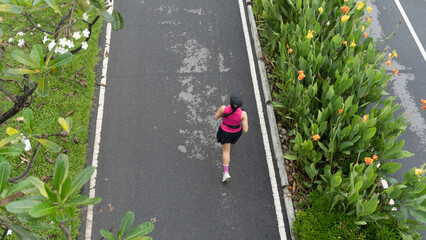 Woman running on a path in a park, overhead view