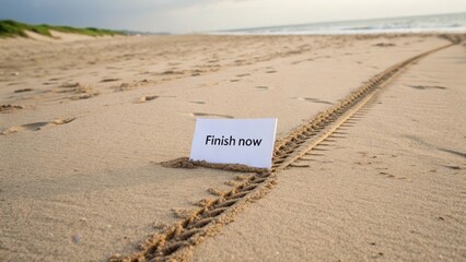 White card on sandy beach with Finish now message