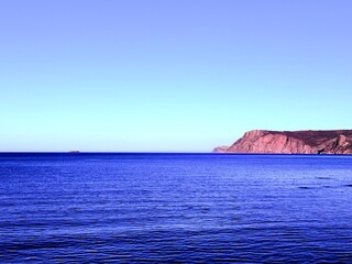 fantastic blue seascape, rocky sea coast, blue sea and blue sky