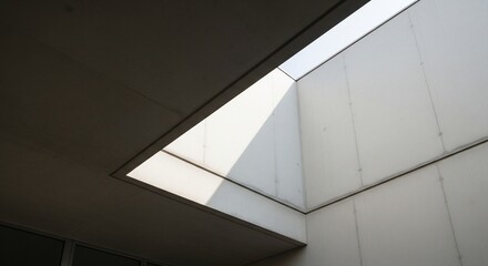 Fototapeta premium Modern architectural skylight illuminating a minimalist interior space with natural light.