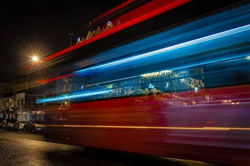 Fototapete Londoner Roter Bus Classic London red bus navigates through a brightly lit street with Christmas decorations and busy foot traffic. Ideal for travel, holiday, or urban lifestyle themes.  © Alexey Fedorenko