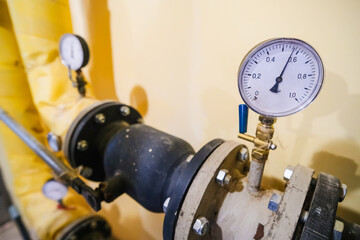 Pipes, shut-off valves and pumps of the heating system in an industrial boiler room