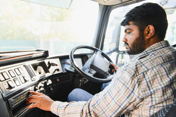 Indian truck driver operating vehicle inside cab