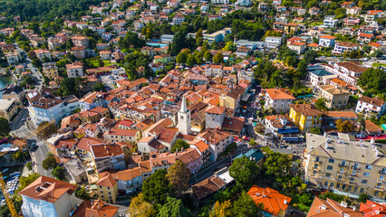 Scenic aerial view of the coastal town Lovran on the Opatija Riviera, Croatia, with red-roofed houses, Adriatic Sea, and green Učka mountain slopes in the background