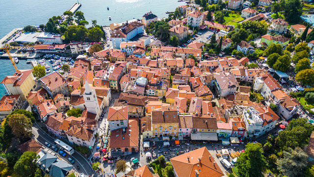 Scenic aerial view of the coastal town Lovran on the Opatija Riviera, Croatia, with red-roofed houses, Adriatic Sea, and green Učka mountain slopes in the background