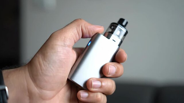 Close-up of a Person Holding a Modern Vape Device in Hand