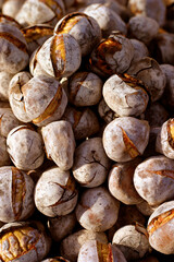 Portugal. Traditional, freshly charcoal roasted, sweet chestnuts in the Autumn sunlight. Popular Autumn - Winter street food throughout Portugal.