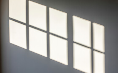 Sunlight casting geometric shadow patterns on a wall