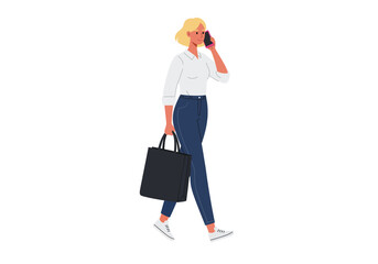A blonde woman walking while talking on the phone and carrying a bag.