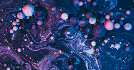 Paint bubbles. Purple oil background. Defocused blue color acrylic blend liquid round wet sphere pigment texture on art abstraction.