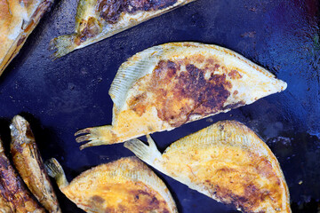 Pieces of fish are grilled at a farmers' market