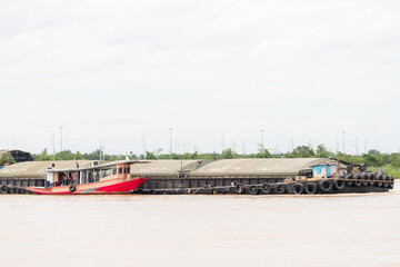 red river tugboat pushing covered cargo barge on inland waterway