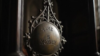 Time and money concept depicted through pendulum motion video representation