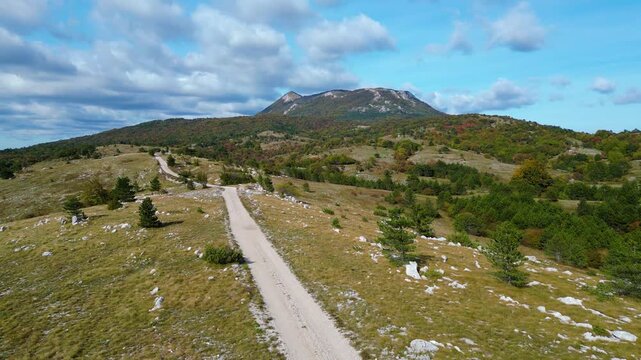 Aerial view of Mount Učka (Ucka) ridge with Vojak peak, winding mountain road, and autumn landscape near Brgud and Mala Učka, Istria, Croatia. Scenic panorama of Učka Nature Park