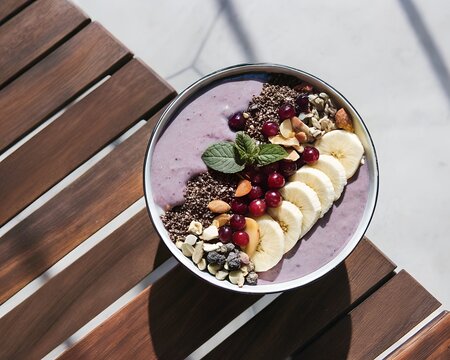 Healthy purple smoothie bowl topped with fruit nuts and seeds