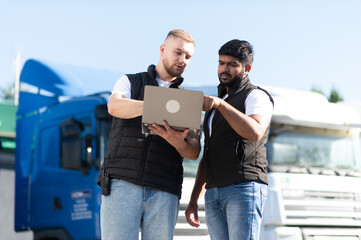 Truck drivers using laptop for logistics planning