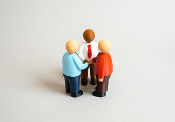 Three office workers holding hands in a circle. Joining forces, cooperation. Partnership. Team unity, trust, leadership, and collective success. Office motivation and corporate culture