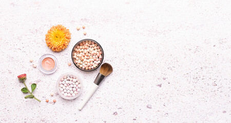 Decorative cosmetic products in autumn colors and beautiful flowers on light marble background top view. Cosmetic sale and promo banner. Copy space for your design.