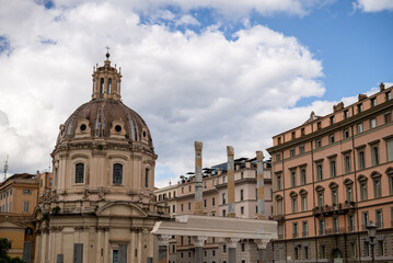 Historic dome church and ancient columns with classic architecture under cloudy sky in Rome