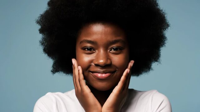 Young black woman with afro hairstyle, wearing a white tshirt, puckering her lips for a kiss and holding her hands up in a playful gesture against a blue background vector illustration